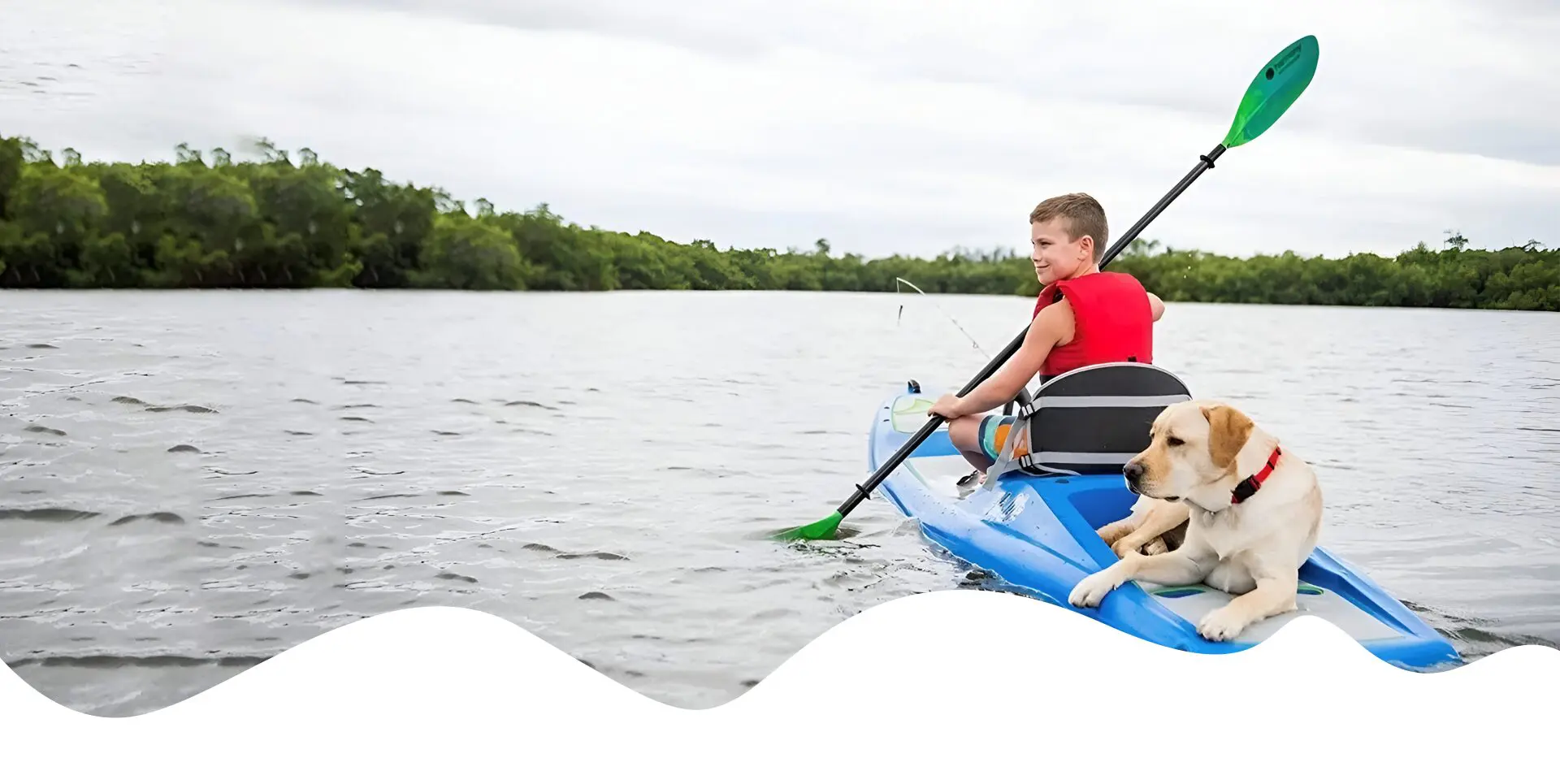 A boy and his dog are kayaking on the lake.