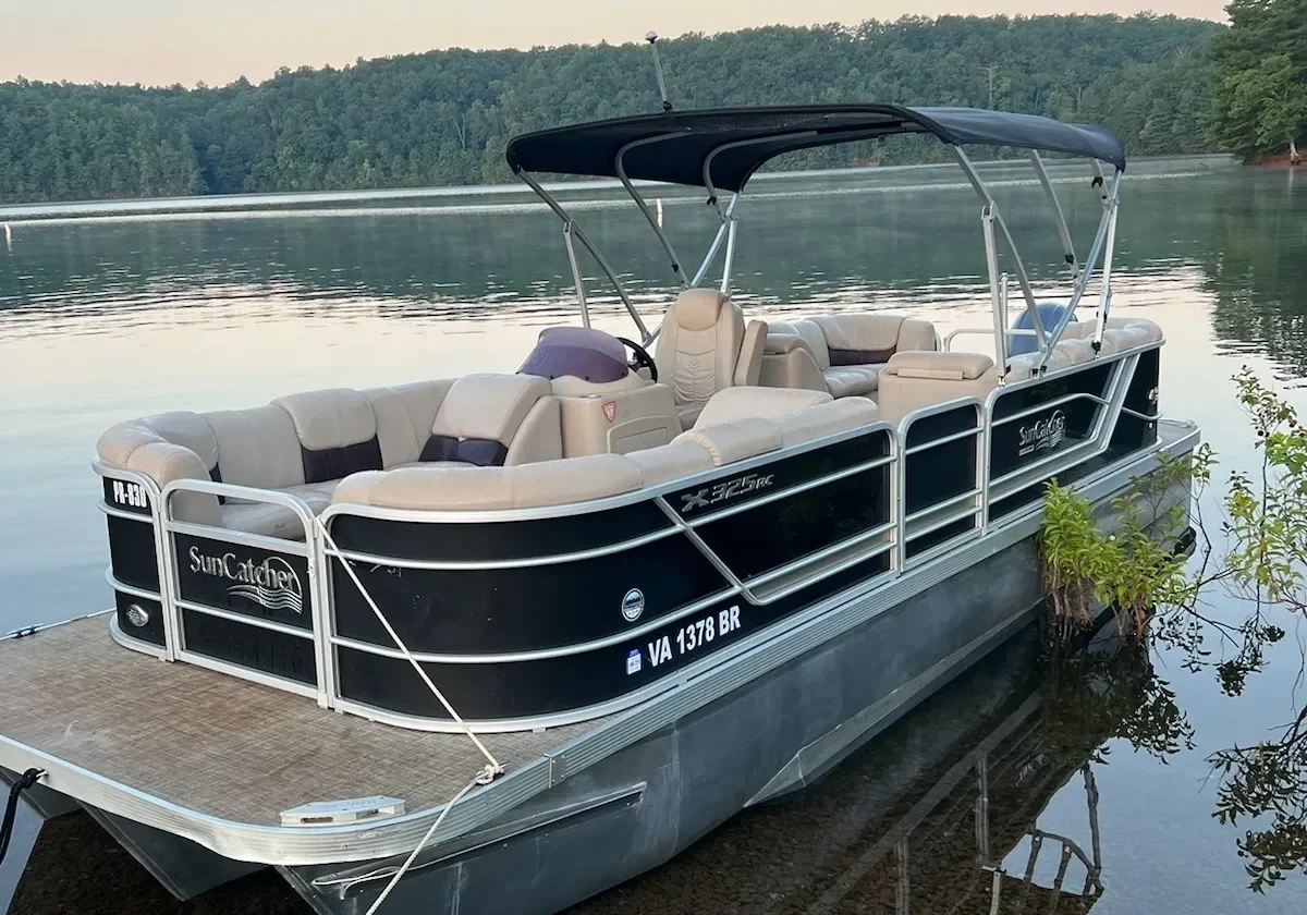 A boat is docked on the water near some trees.